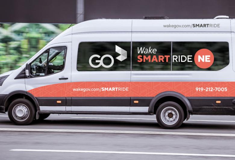 Wake SmartRide van drives down a city street.