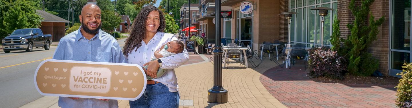 Two people with child holding giant bandage