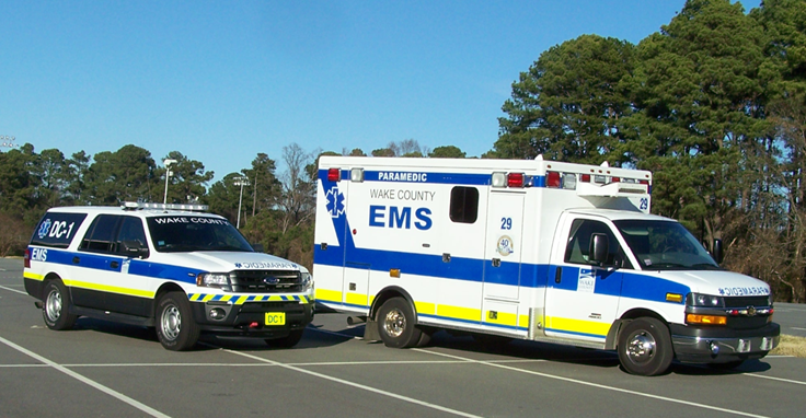 Wake County ambulance and district chief SUV under a beautiful blue sky.