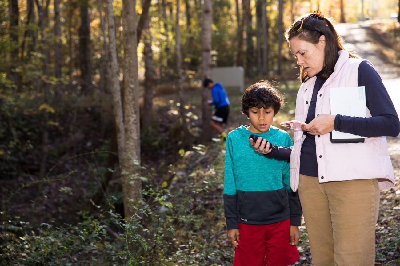 Photo of a family using GPS units to locate a geocache on the American Tobacco Trail