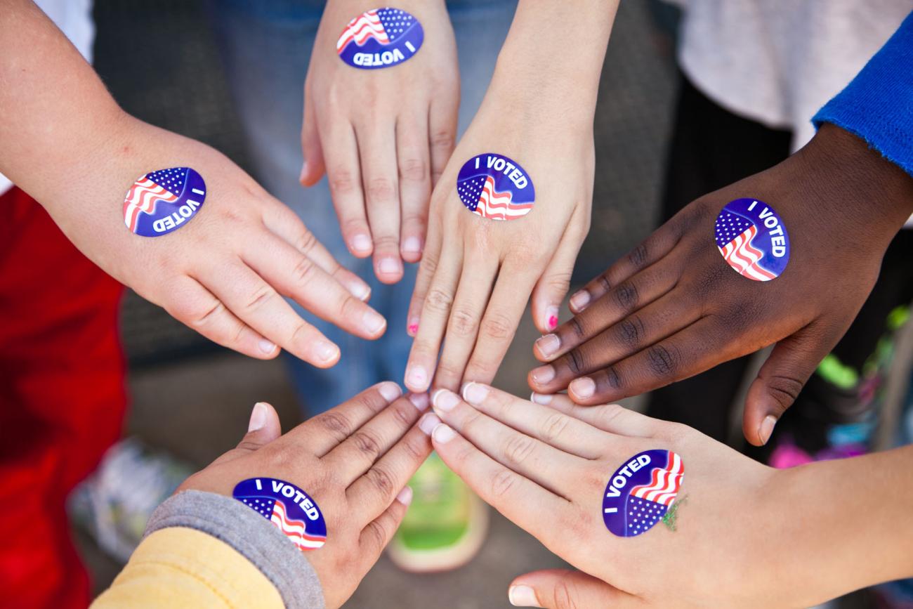 Six hands coming together with I Voted Stickers