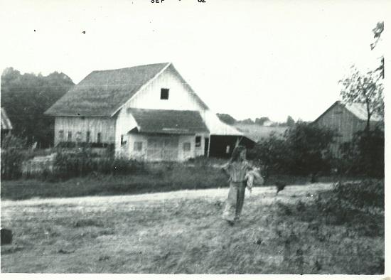 Black and white image of the Livestock Barn taken in the 1960s with girl running in front of barn