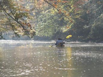 Picture of someone kayaking down the river