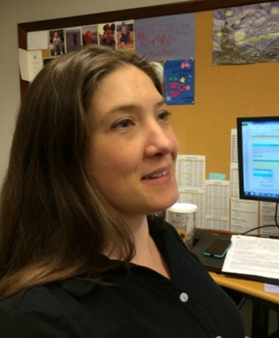 Amy Brock smiling at her desk