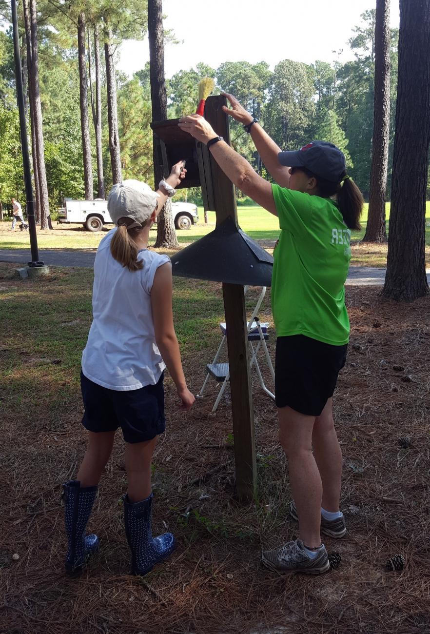 Photo of two volunteers cleaning a bluebird nest box during Citizen Science Thursday