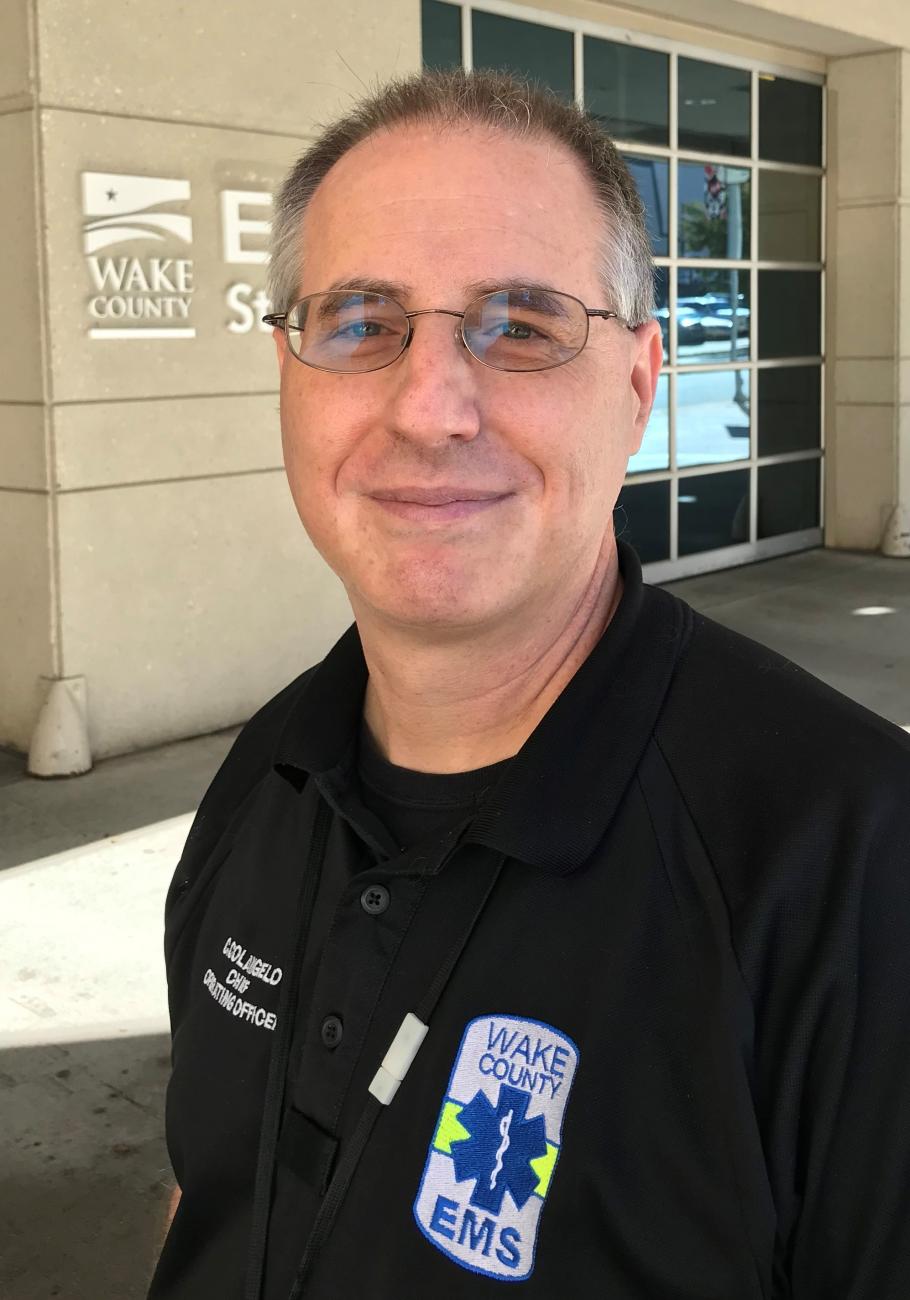 Chris Colangelo smiling in front of ambulance bay