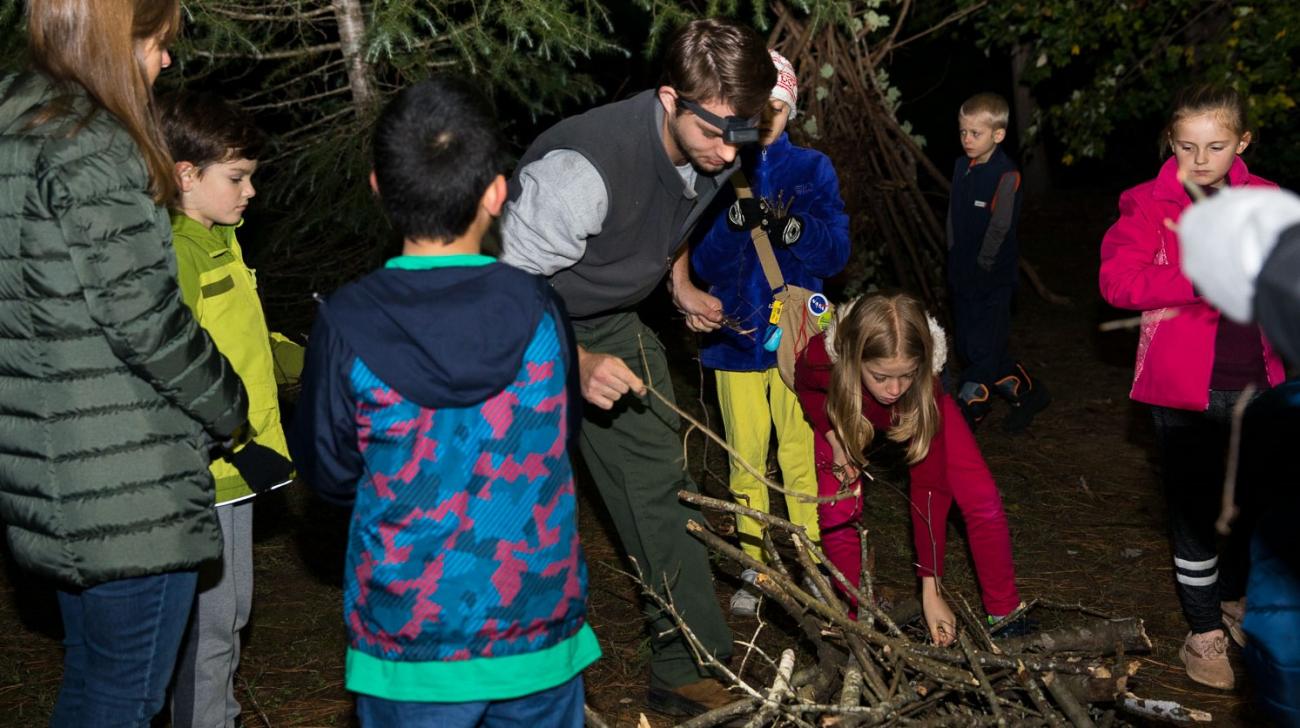 Programmer shows children how to build a fort during a night program