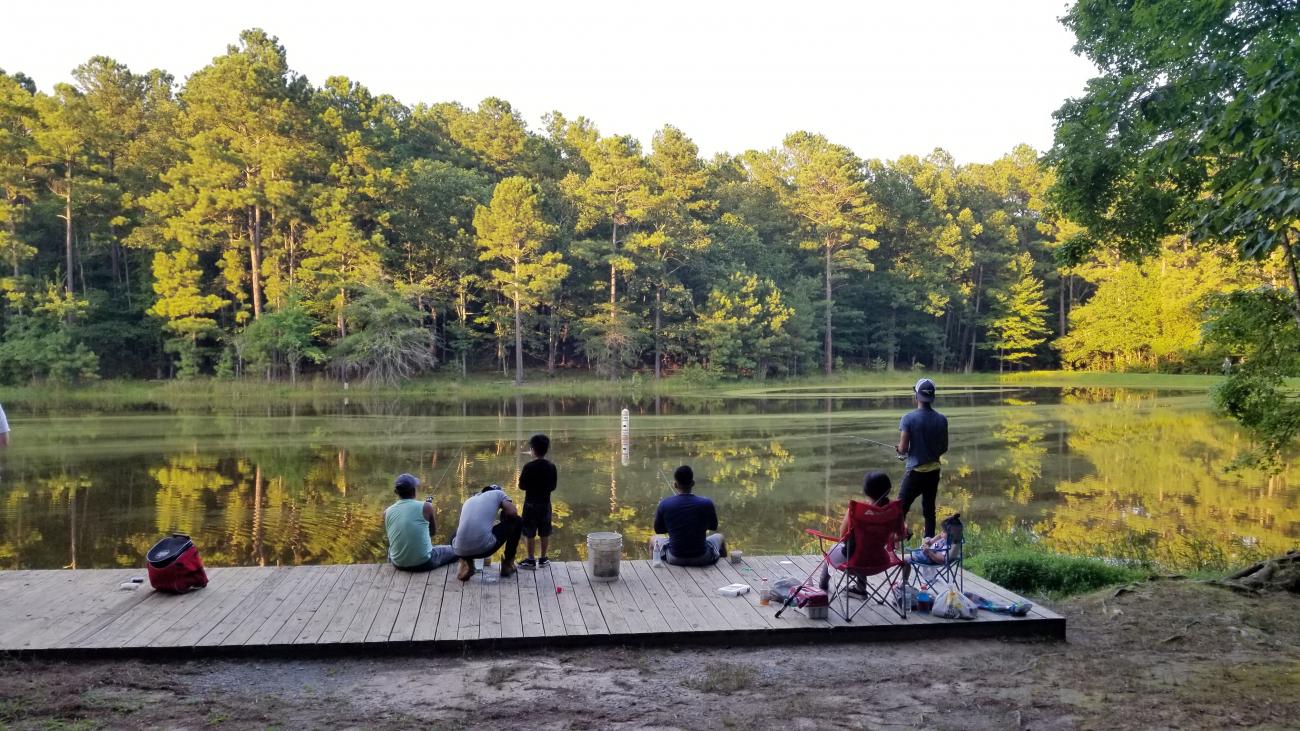 Photo of a family fishing together on the dock located at the Fishing Pond