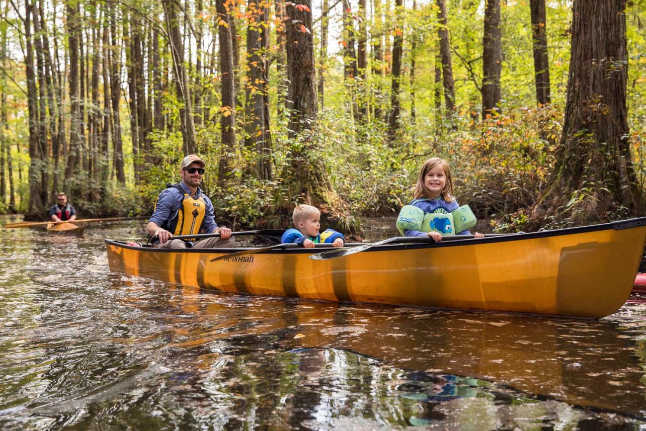 Man and his two children canoeing on Robertson Millpond