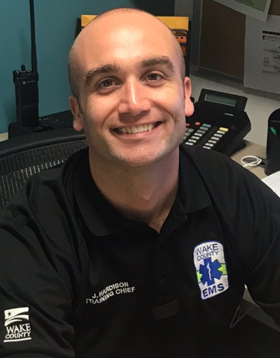 Jake Hardison smiling at his desk