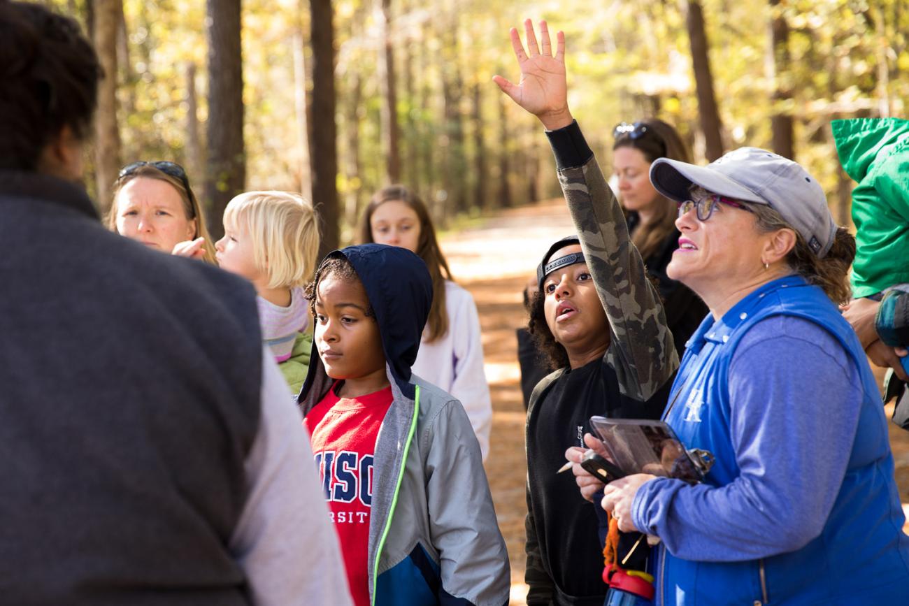 child raises hand at park program