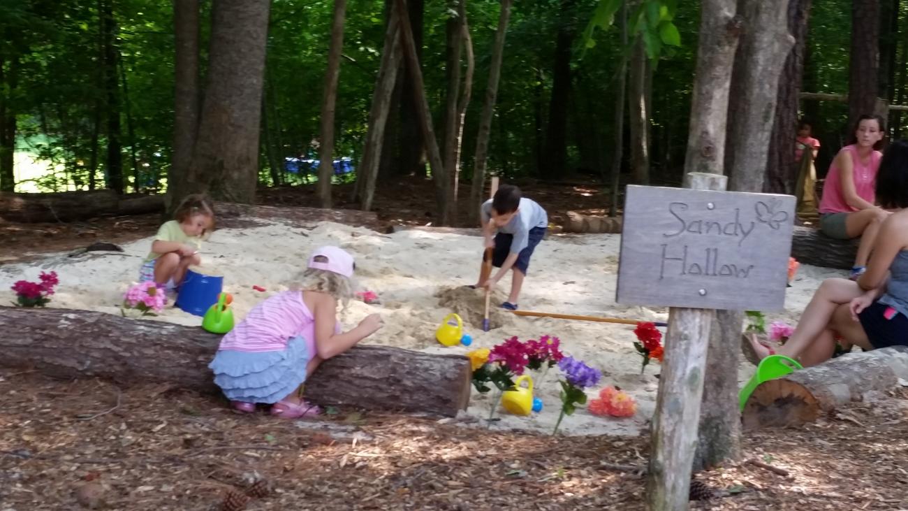 Children using thematic "loose parts" in a natural play area during a Nature Play Day