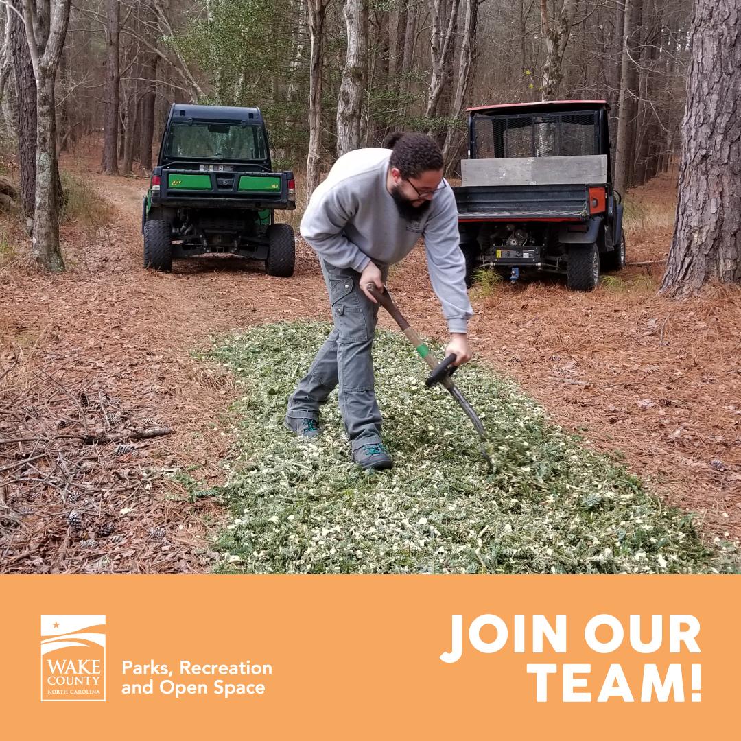Park staff spreading mulch on a trail.