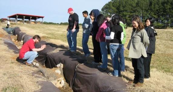 Students observe soils demonstration at NCSU research farm