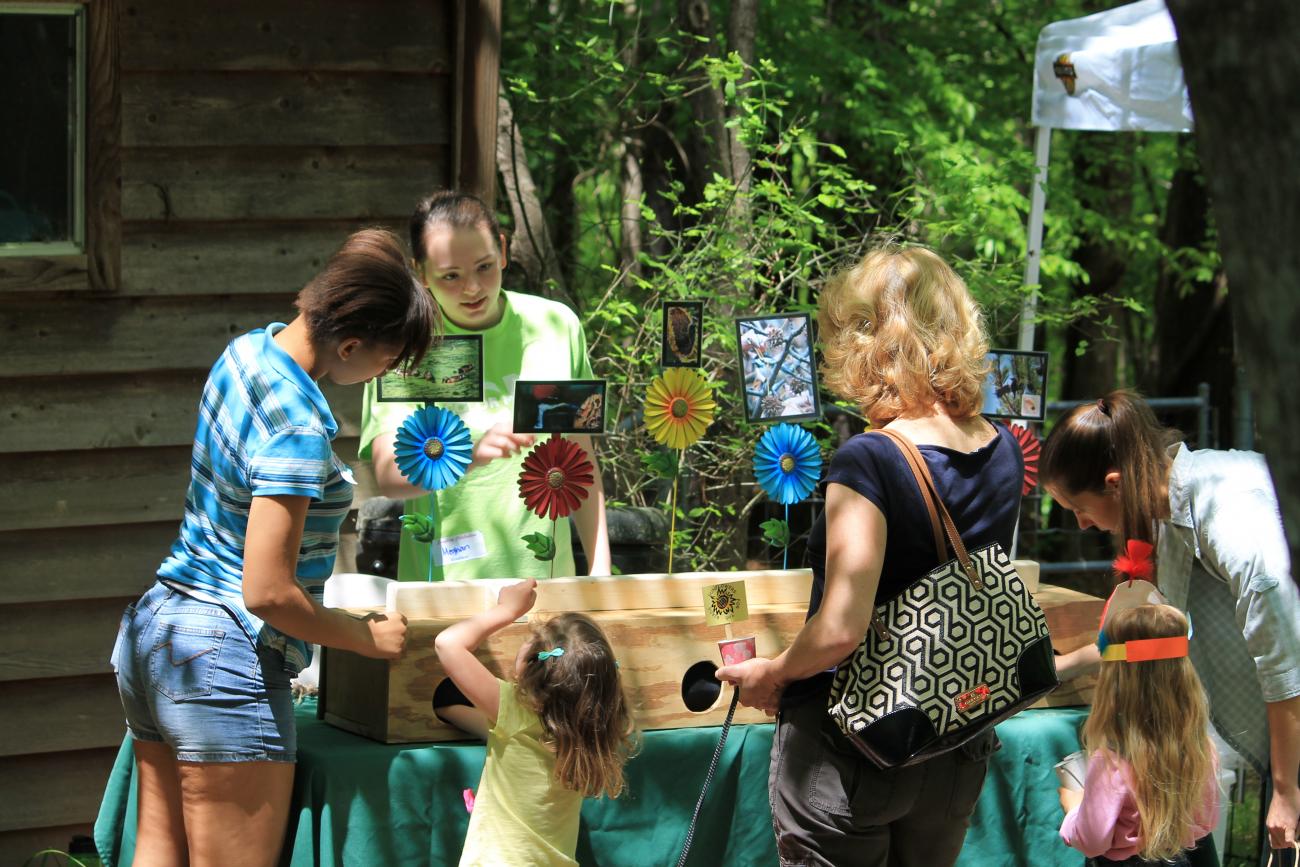 Older girl scout staffing an educational activity booth at Songbird Celebration