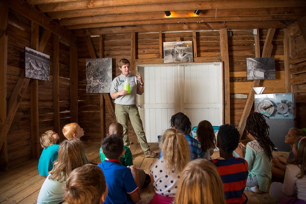 School group seated listening to a program in the historic Cotton Gin House