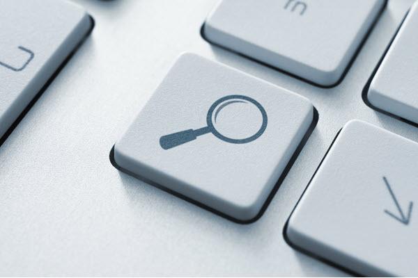 close-up of a keyboard with a magnifying glass on one of the keys