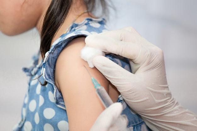Young girl getting a flu shot by a doctor.