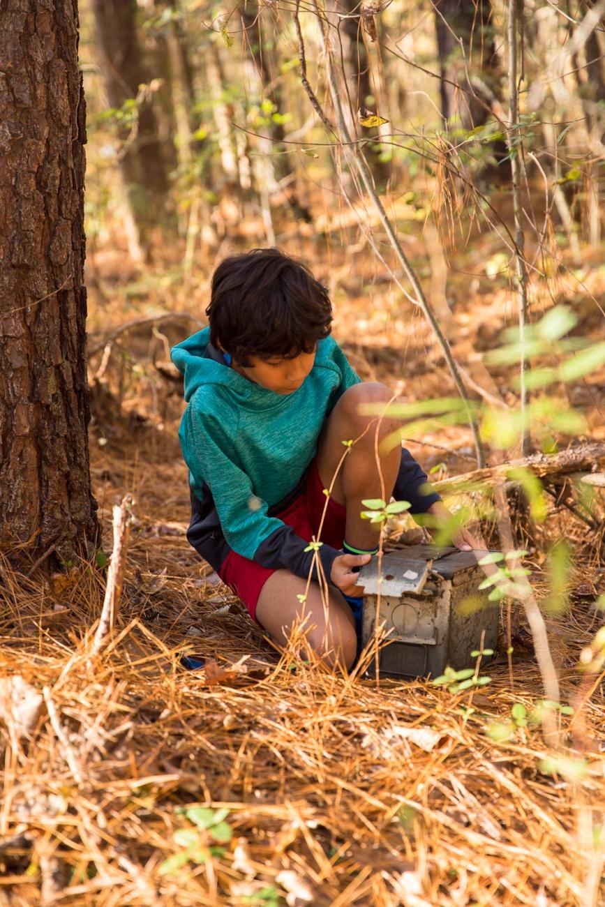Photo of a young man who has found a hidden geocache