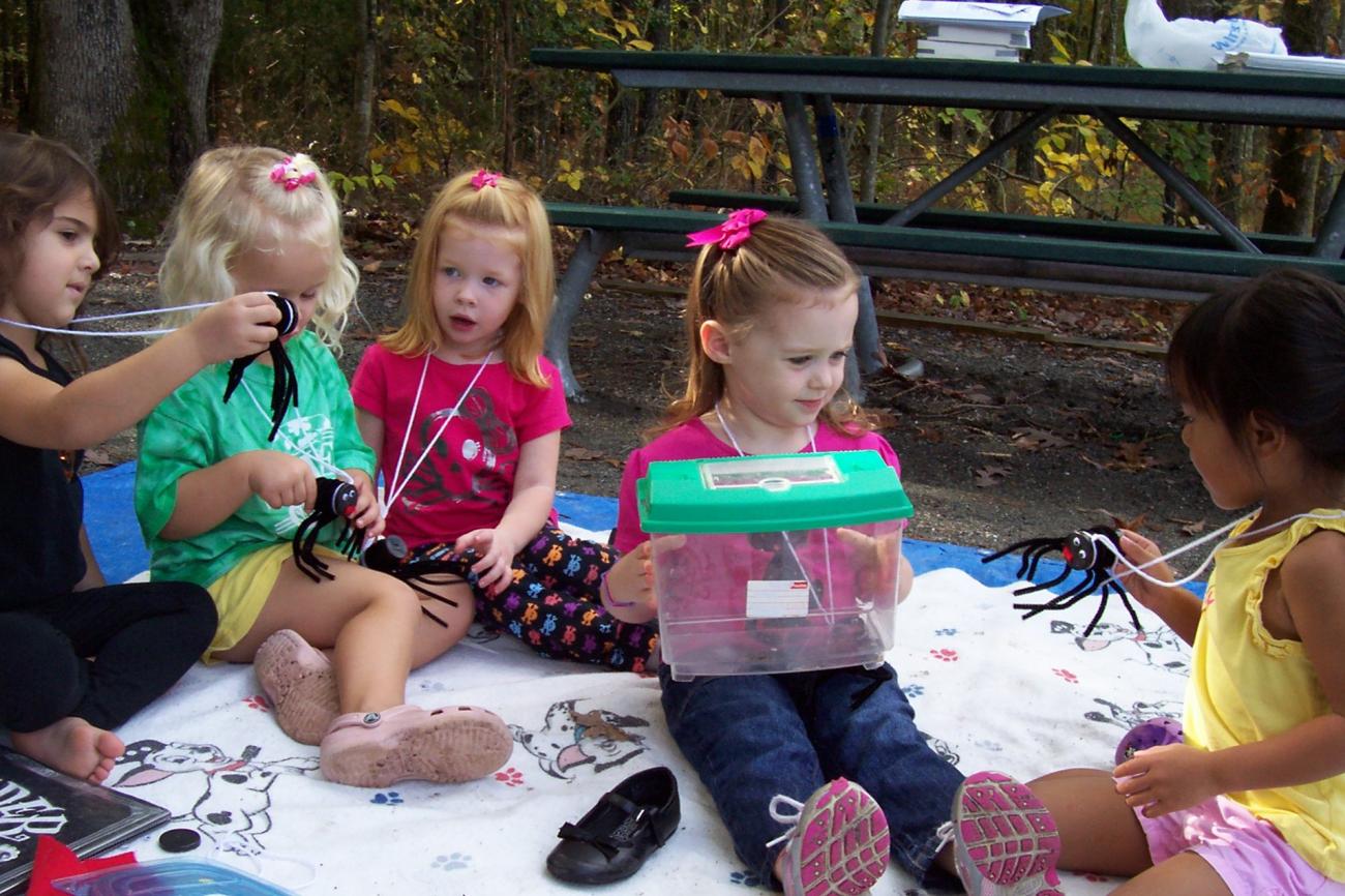 Photo of young kids sitting on a blanket at a program