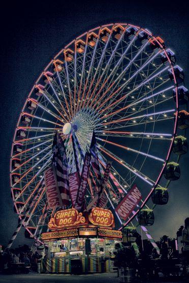 ferris wheel at night with hot dog stand