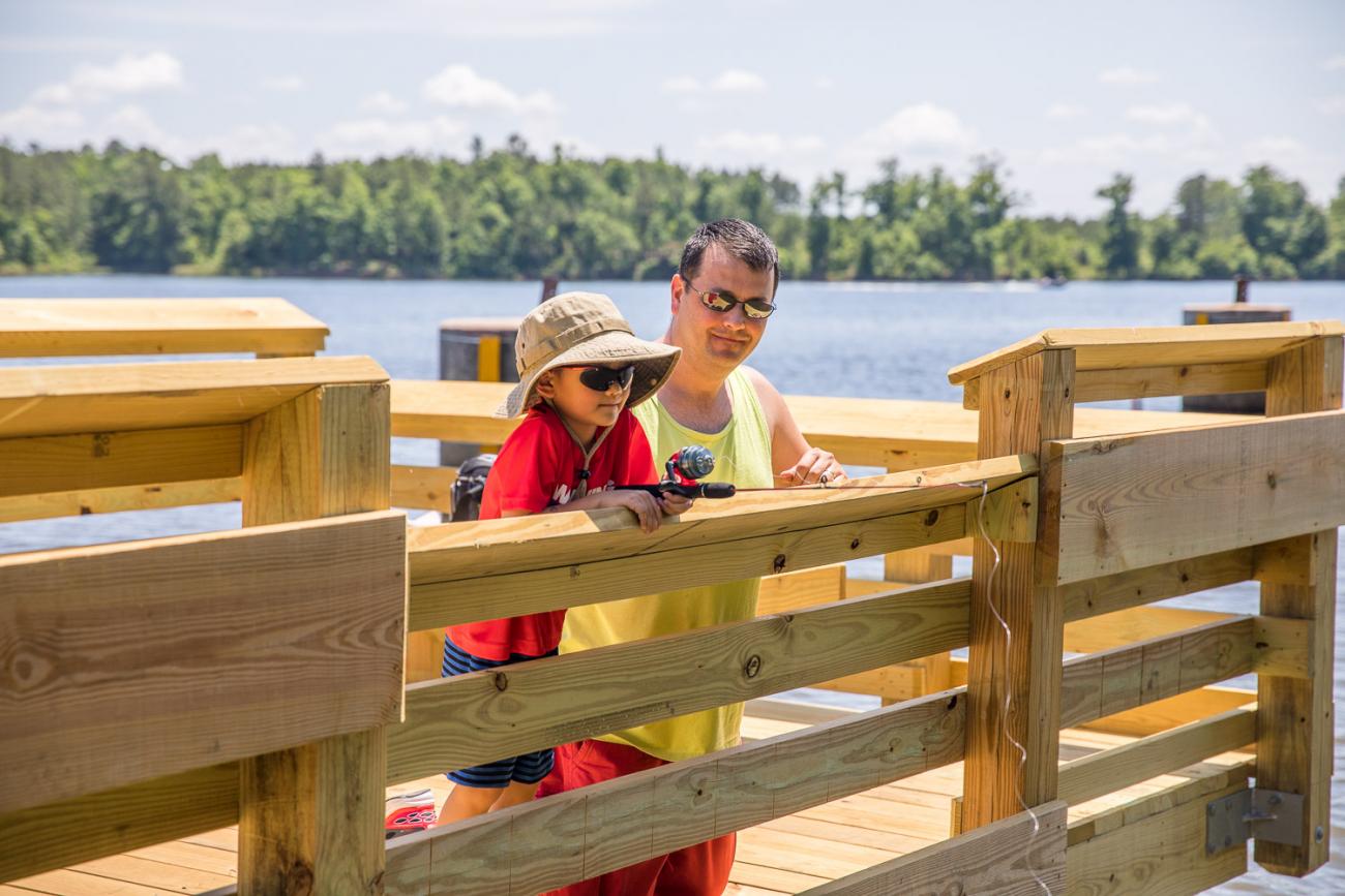 Photo of a father and son fishing together from the Fishing Pier at Harris Lake County Park