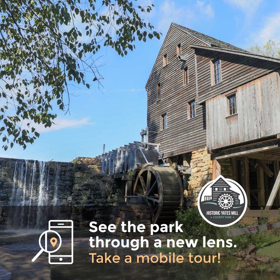 wooden mill building beside ponds edge promoting park mobile tour