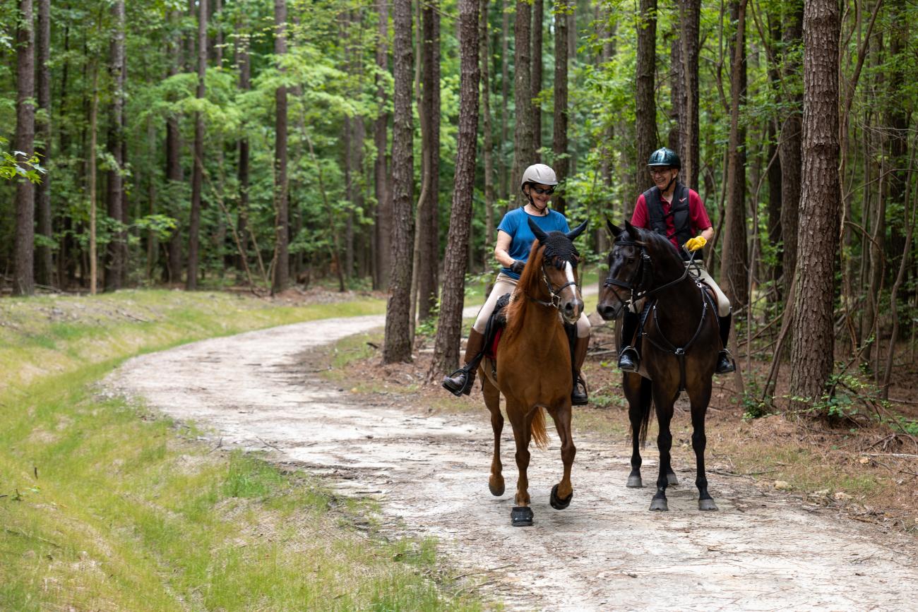 Two horseback riders smiling
