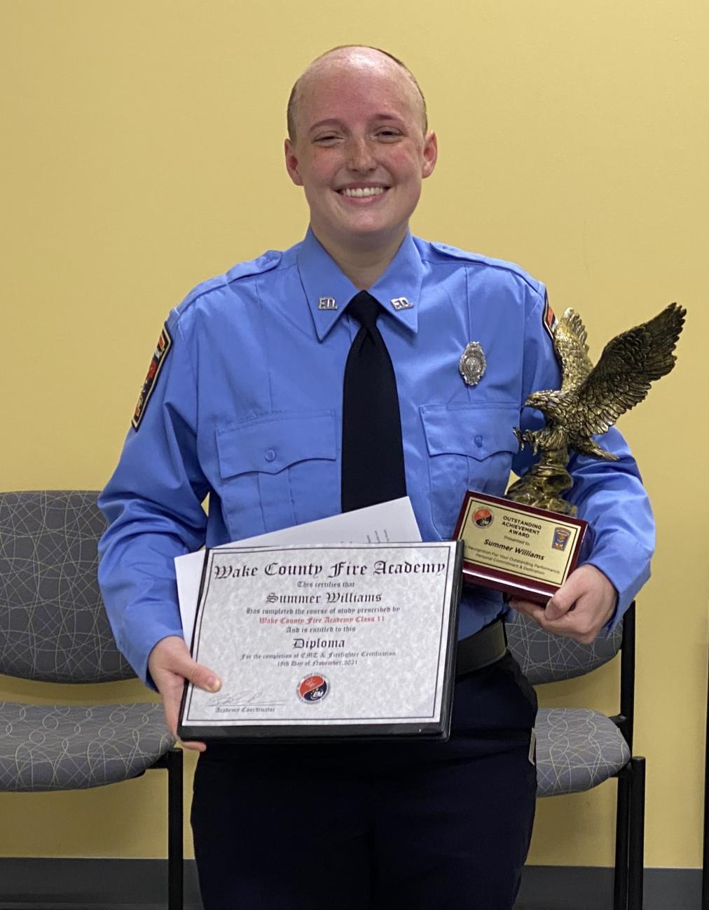 Wake County Fire Academy graduate Summer Williams smiles with her diploma and achievement award